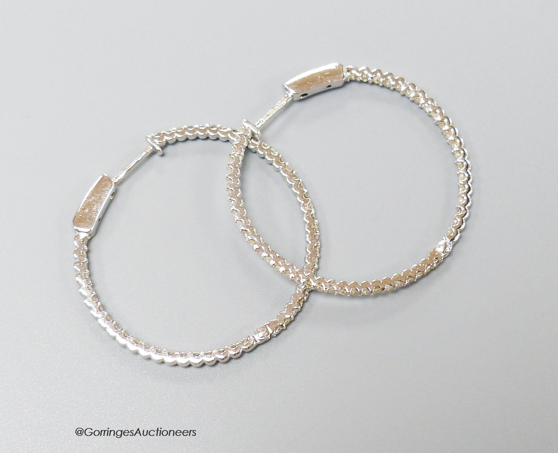 A modern pair of 18ct white gold and diamond chip set hoop earrings, diameter 32mm, gross weight 5.4 grams.